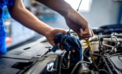 Photo of Unrecognizable male mechanic measuring the oil level of an engine at an auto shop. Mechanic checking the oil level in a car service garage. Repairing engine at a service station. Car repair."r"n.